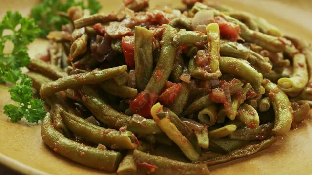 Taze fasulye - Turkish style string beans. A popular meze and summer food. Onion, garlic, tomato, green bean and a lot of olive oil. Table spin.