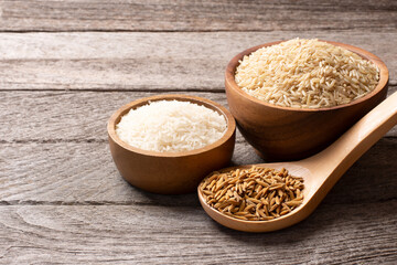 Set of raw rice ; paddy rice, brown coarse rice and white thai jasmine rice in wooden bowl isolated...