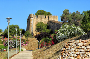 Fototapeta na wymiar Europe, Portugal, Algarve, Lagos, historic fortified walls form a protective ring around the old historic centre, seen from the outside, quiet city park with flowering oleanders