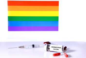 Capsules,syringe and vial rainbow flag in the background
