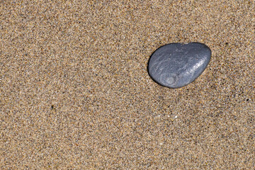 A small stone rounded by the erosion of sand and waves