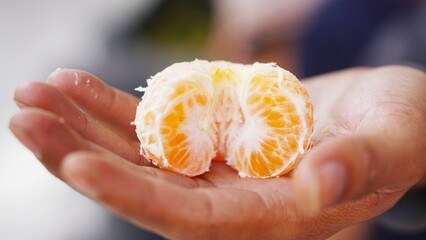 Sweet and ripe yellow orange in hand ready to be served