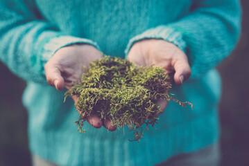 Close up of human hands holding natural green musk. Concept of earth's day and stop climate change....