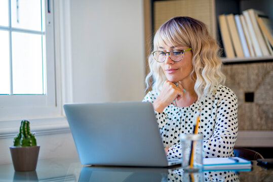 Modern Freelance Entrepreneur Woman Working On A Laptop In Home Studio Workplace. Happy Female Smiling In Front Of Computer Doing A Video Call Conference. Job Online People Business On Web Internet