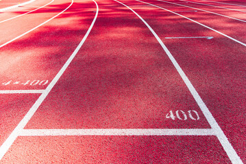 Bright red running track with white line and number 400.Close-up.