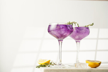 a purple drink in a vintage glass for sparkling wine - pea flower tea or blue curacao sirup...
