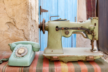 Old retro items found on a traditional market in Dubai. Sewing machine and analog telephone.