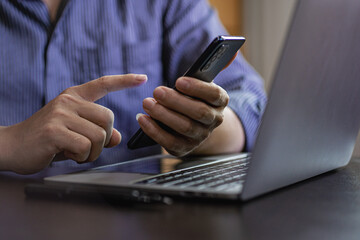 A businessman holding a smartphone working on project statistics on the device is ready. Graph presentation, notebook, entrepreneur, financial market data analysis. that represents a change