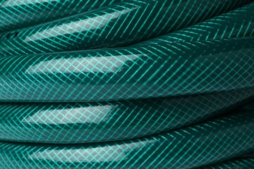 Green rubber watering hose as background, closeup