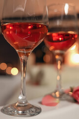 Wine in glasses on edge of bath indoors, closeup. Romantic atmosphere