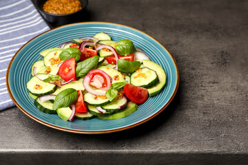Tasty salad with cucumbers served on grey table