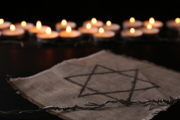 Fabric with star of David and barbed wire on black background. Holocaust memory day