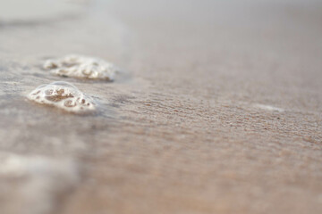 Fototapeta na wymiar macro of a bubble on a white sand sea beach