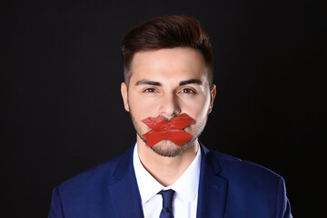 Man with taped mouth on black background. Speech censorship