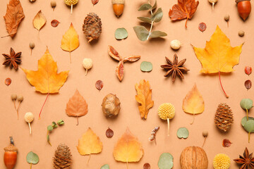 Flat lay composition with autumn leaves on pale orange background