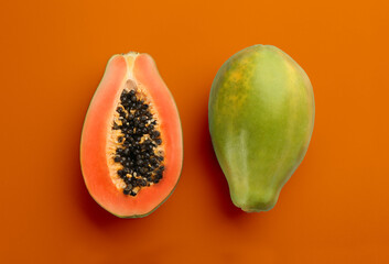 Fresh ripe papaya fruits on orange background, flat lay