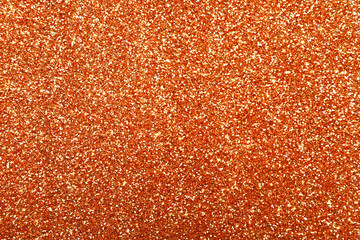 Beautiful shiny orange glitter as background, closeup