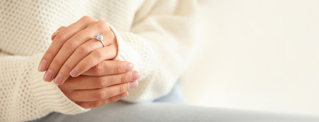 Young woman wearing beautiful engagement ring, closeup view with space for text. Banner design