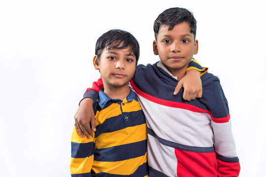 Two boys standing close with hands over each others shoulder