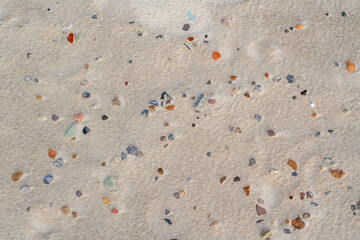 texture of multicolored pebbles and shells in the sand
