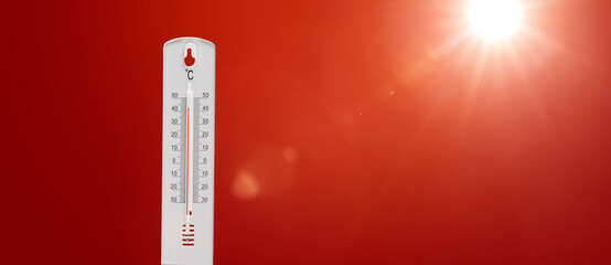 Thermometer mit heissen Celsiusgraden vor rotem Hintergrund