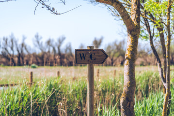 Wooden sign of a public toilet in the natural reserve.