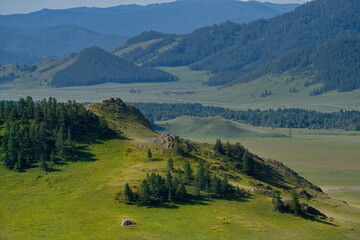 Obraz premium Russia. South of Western Siberia, Mountain Altai. Picturesque hilly mountains covered with a solid green carpet with many alpine flowers near the village of Ust-Kan.