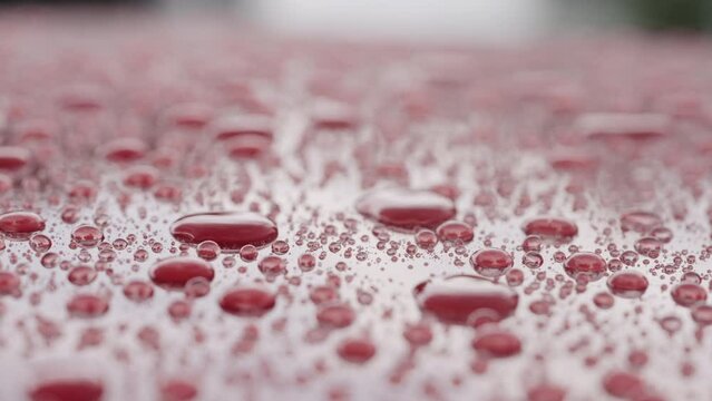 Slow motion of ceramic coated car under rain, water drops sliding from car
