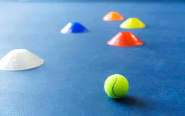 Colorful plastic cones on a blue cement tennis court