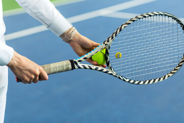 Woman tennis player holding ball and racket in her hands © ribalka yuli