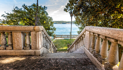 Old stairs leading to a beautiful backyard towards a lake, luxury lifestyle