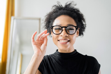 Portrait of a coach a financial coach a woman with glasses in a video chat looks at the screen, works in an office at a workplace in a coworking space