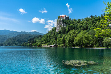 Fototapeta na wymiar Beautiful idyllic panorama view of Lake Bled with Bled Castle and Slovenian Julian Alps in background on sunny summer day with blue sky cloud, Bled, Slovenia