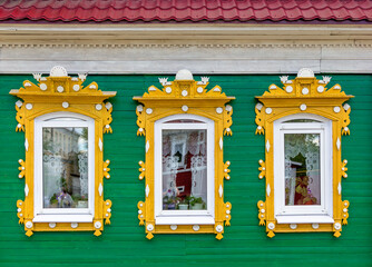 The beautiful old windows with beautifully designed platbands window on an old wooden house in...