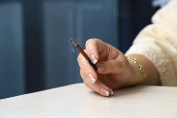 sexy woman with nail polish smokes