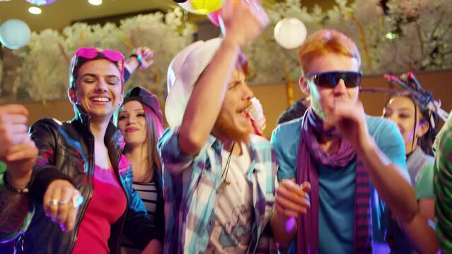 Footage of a crowd or group of young, stylish multi-ethnic people during colorful party in different clothes . Dancers having fun dancing at a party . Shot on RED HELIUM Cinema Camera in slow motion .