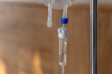 Close-up view of a medical intravenous drip with a fluid drop for a patient's treatment