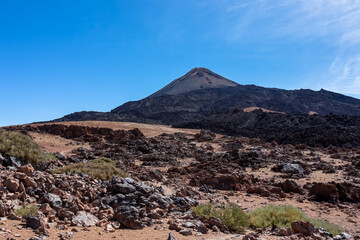 Solidified lava, ash and pumice on volcanic terrain. Black and brown dark sand and rocks on bare terrain. Scenic view on volcano Pico del Teide, National Park, Tenerife, Canary Islands, Spain, Europe