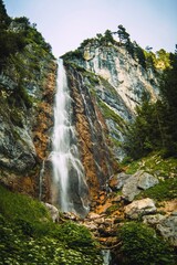 Dalfazer Wasserfall. Beautiful waterfall in Tirol Alps. Beautiful landscape with green trees, rocks and blue sky with clouds in the mountains. Summer landscape scene from nature, Tirol Alps, Austria
