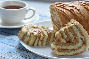 breakfast roll with boiled condensed milk on the background of a cup of tea