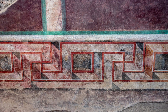 POMPEII, ITALY - MAY 04, 2022 - Scenic geometric bordure in a fresco of an ancient Roman villa in Pompeii