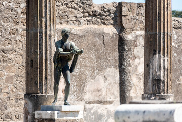 POMPEII, ITALY - MAY 04, 2022 - Colonnade and sculptures of the Temple of Apollo near the Pompeian forum, Italy