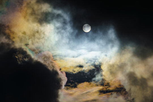 Diffraction of light on drops of supercooled water in clouds, rainbow clouds against the blue sky in clear sunny weather, irisation of cumulus clouds, optical phenomenon, spectral colors