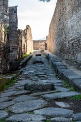 POMPEII, ITALY - MAY 04, 2022 - A crosswalk of a typical Roman road in the ancient city of Pompeii, Italy