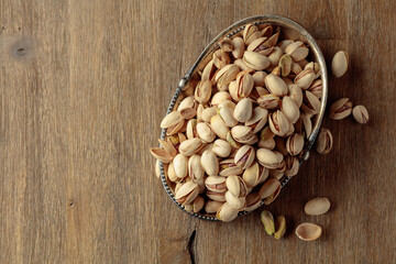 Salted pistachios on an old wooden table.