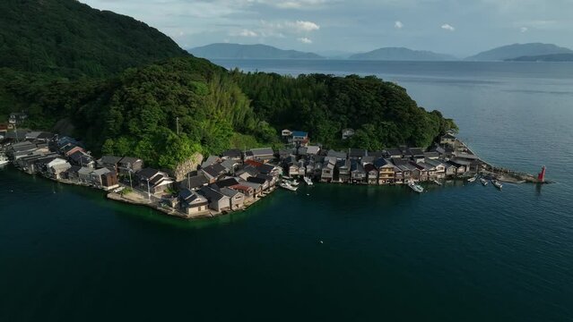 Rising over traditional boathouses in small coastal fishing village of Ine, Kyoto