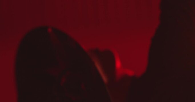 Beautiful hat dressed girl dancing latin dance . Professional female dancer dancing flamenco , rumba or salsa on red background with lines . Spanish dance movements . Shot ARRI ALEXA Cinema Camera .