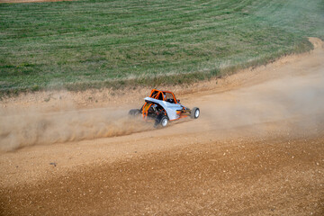 buggies on the autocross track, skidding, dust and dirt flying under the tires