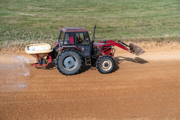 Obraz premium the tractor treats the chemistry of the autocross tracks before the races