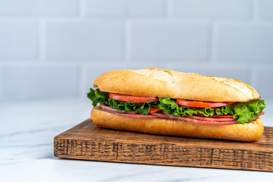 Deli sandwich with drink on light surface